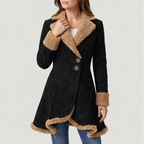 Woman wearing a black suede coat with a tan faux fur collar, cuffs, and asymmetric hemline, accented by two round buttons.