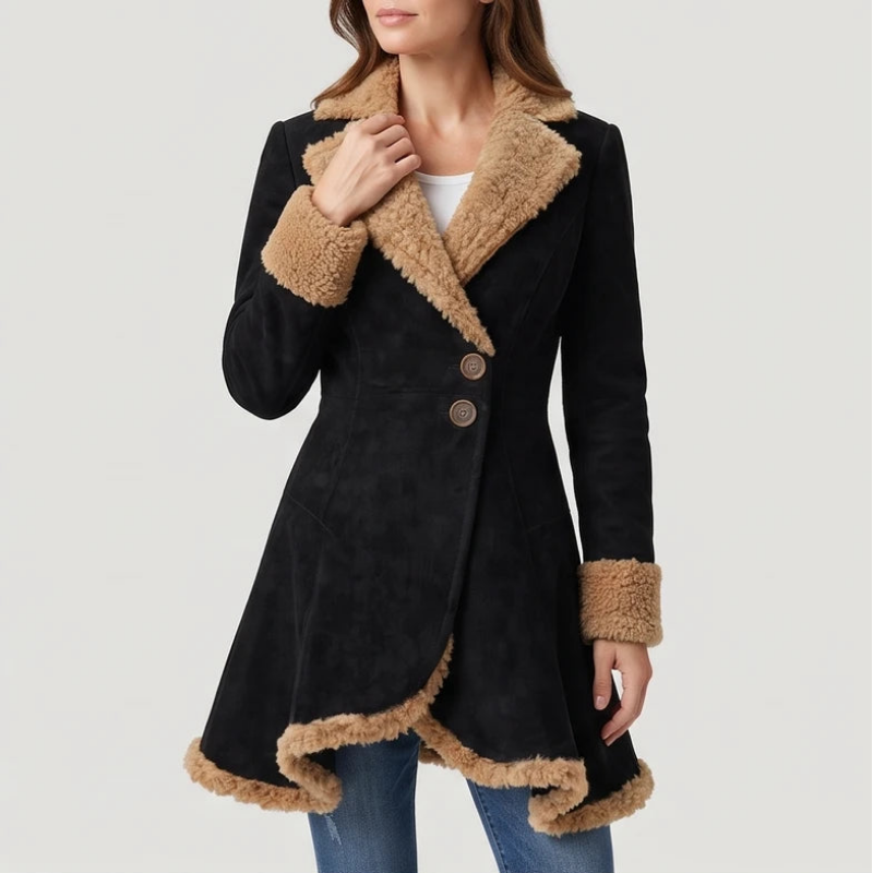Woman wearing a black suede coat with a tan faux fur collar, cuffs, and asymmetric hemline, accented by two round buttons.