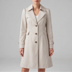 Woman wearing a beige trench coat with a wide collar, visible stitching, and three brown buttons on a neutral background.