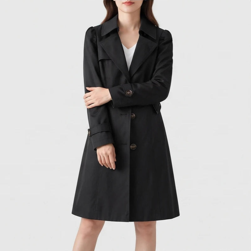 Woman wearing a black trench coat with puffed shoulders, large lapels, and three dark brown buttons on a white background.